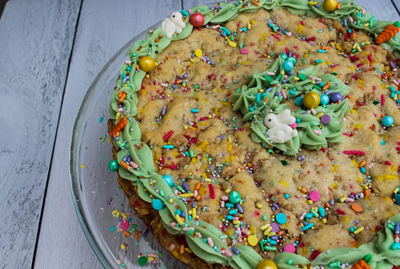 This Spring Sugar Cookie Cake is an easy sweet treat to bring a smile to faces this spring. Rich in vanilla flavor and topped with a bit of spring-colored frosting and festive sprinkles, this Spring Sugar Cookie Cake is simply irresistible. 