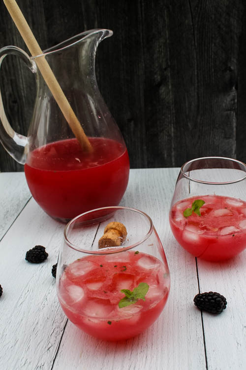 A make ahead cocktail to serve a crowd, this Blackberry Tequila Cooler combines sweet blackberries, tart lime, and bubbly wine for a light and refreshing summer cocktail.