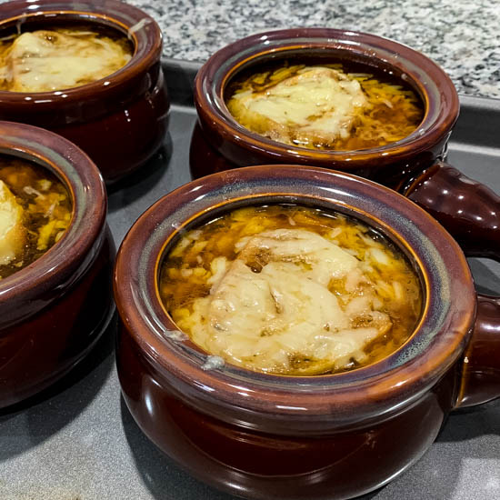 Barefoot Contessa's Onion and Fennel Soup Gratin is a deliciously rich soup - caramelized onions and fennel in a buttery beef broth, topped with savory cheese and a thick slice of bread. Enjoy it as an appetizer or a meal in and of itself.