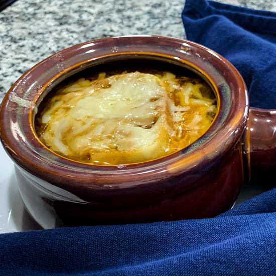 Barefoot Contessa's Onion and Fennel Soup Gratin is a deliciously rich soup - caramelized onions and fennel in a buttery beef broth, topped with savory cheese and a thick slice of bread. Enjoy it as an appetizer or a meal in and of itself.