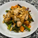 Sheet Pan Spicy Peanut Chicken & Veggies: Chicken, sweet potatoes and your choice of veggies are roasted on a sheet pan and then topped with a spicy peanut sauce and crunchy peanuts for a balanced, flavorful meal. 