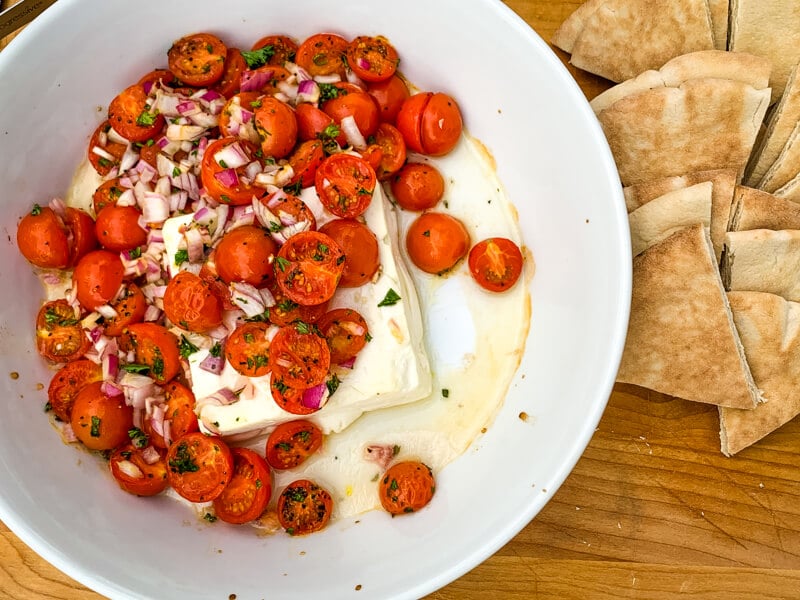 This Mediterranean Baked Feta is an irresistible, quick and easy summer appetizer. Pile salty feta with sweet cherry tomatoes and herbs and heat in the oven until warmed throughout. Easy peasy!