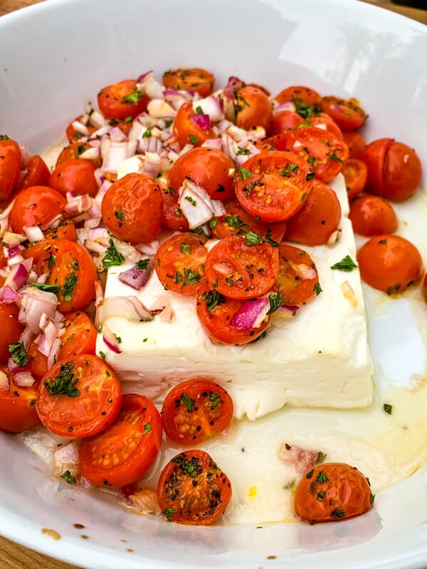 This Mediterranean Baked Feta is an irresistible, quick and easy summer appetizer. Pile salty feta with sweet cherry tomatoes and herbs and heat in the oven until warmed throughout. Easy peasy!