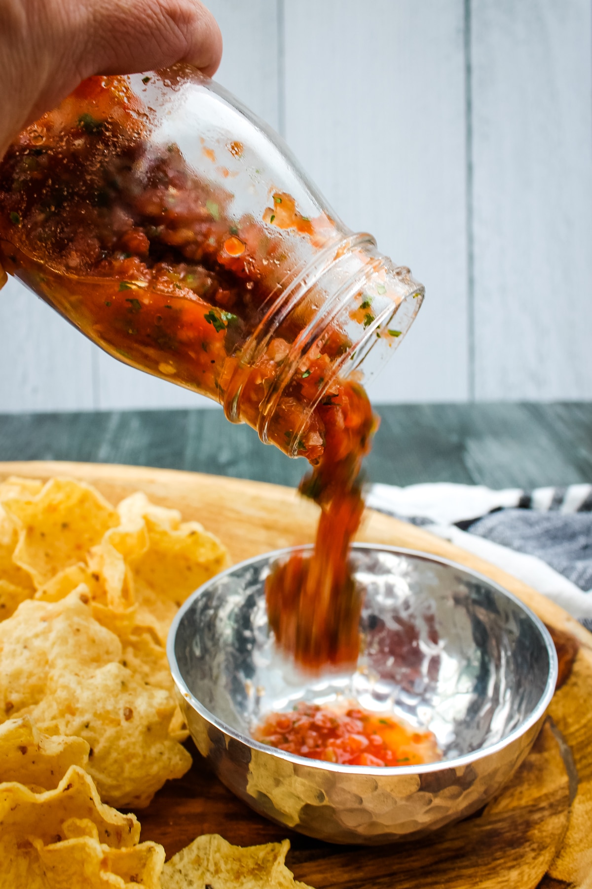 side view of restaurant style salsa being poured into a bowl