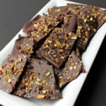 Cranberry-Pistachio Dark Chocolate Bark - Dark Chocolate Bark is studded with sweet dried cranberries and salty pistachios, and finished with a sprinkling of sea salt – perfect for dessert to an elegant wine and cheese pairing or for a holiday gift.