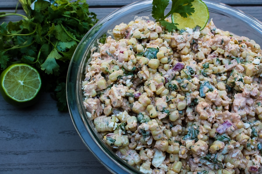 This Mexican Street Corn Salad is a hit at potlucks and BBQs, and always disappears quickly. It is all the best parts of Mexican Street Corn, Elote, but with less mess - grilled corn, a creamy sauce bursting with flavor from spices and fresh herbs, and salty cheese. You and your guests will want seconds!