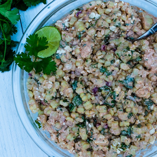 This Mexican Street Corn Salad is a hit at potlucks and BBQs, and always disappears quickly. It is all the best parts of Mexican Street Corn, Elote, but with less mess - grilled corn, a creamy sauce bursting with flavor from spices and fresh herbs, and salty cheese. You and your guests will want seconds!