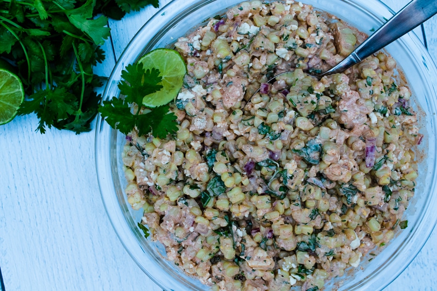 This Mexican Street Corn Salad is a hit at potlucks and BBQs, and always disappears quickly. It is all the best parts of Mexican Street Corn, Elote, but with less mess - grilled corn, a creamy sauce bursting with flavor from spices and fresh herbs, and salty cheese. You and your guests will want seconds!