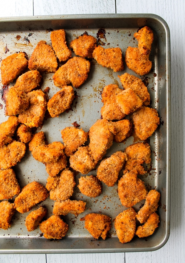 Overhead view of baked buffalo chicken nuggets still on baking sheet, fresh from the oven