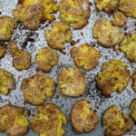 Crispy smashed dutch potatoes on a baking sheet, fresh from the oven.