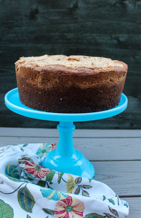 Side view of sour cream coffee cake with toasted pecan filling, set on a blue cake stand