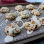 Side view of fruitcake cookies and glaze drippings on a baking sheet