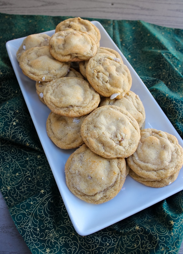 view from above, honey walnut cookies on a white dish, set on top of a green and gold cloth