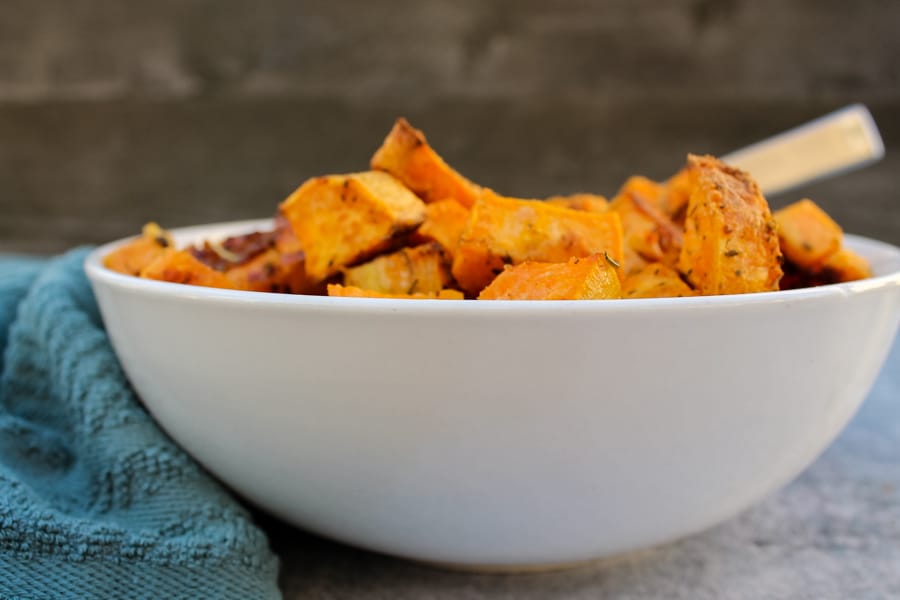 side view of Parmesan & Garlic Roasted Sweet Potatoes in a while bowl