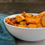 side view of Parmesan & Garlic Roasted Sweet Potatoes in a white bowl