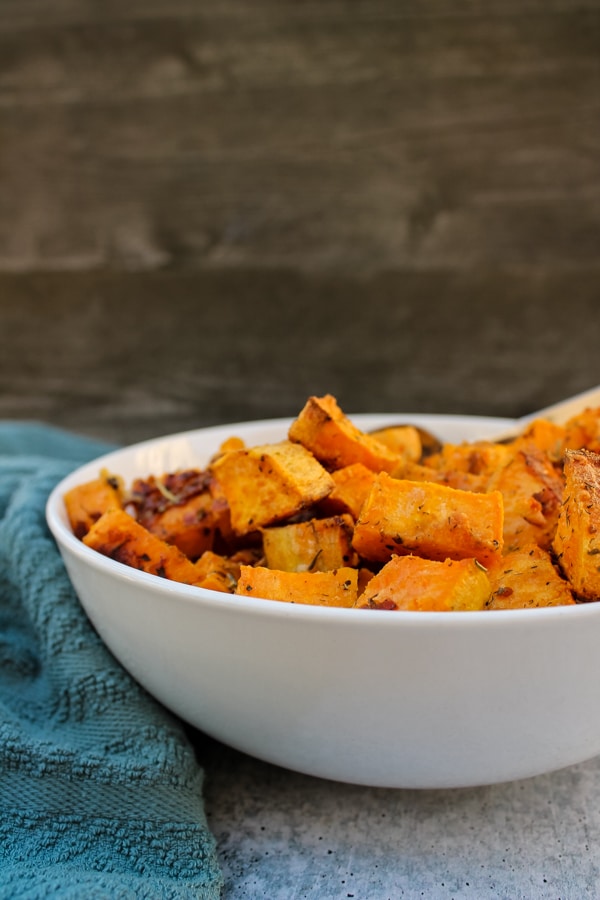 side view of Parmesan & Garlic Roasted Sweet Potatoes in a white bowl