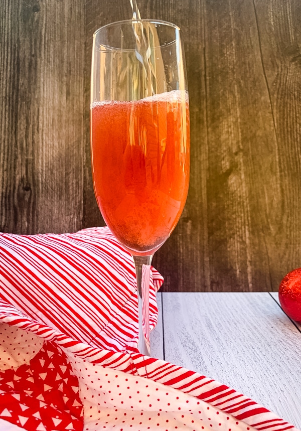 side view of bubbly being poured into a Poinsettia Champagne Cocktail 