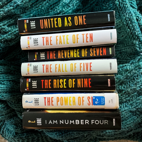 picture of the spines of the 7 books in the Lorien Legacies series by Pittacus Lore