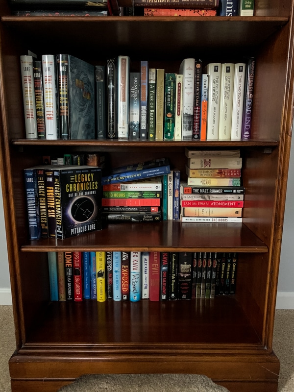 3 shelves of a bookshelf filled with books