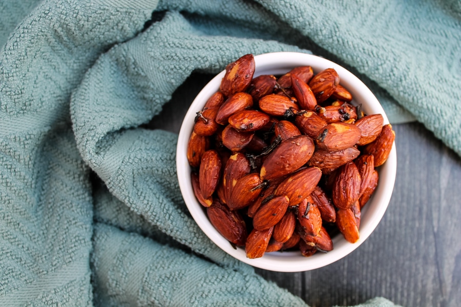 overhead view of honey and rosemary almonds in a small white bowl