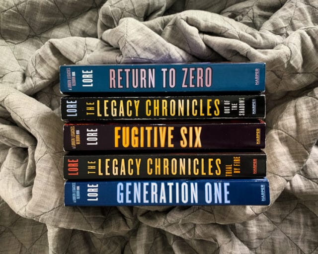 overhead view of the spines of the books in the Lorien Legacies: Reborn and The Legacy Chronicles series