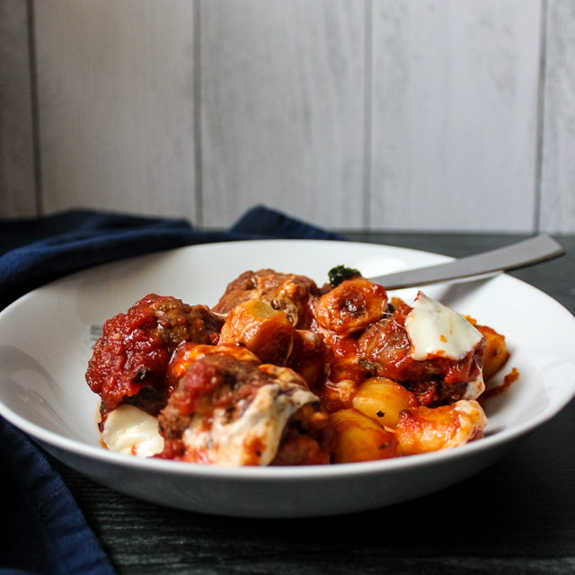 side view of a white bowl with Italian meatball gnocchi bake