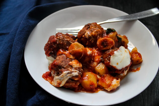 overhead view of a white bowl with Italian meatball gnocchi bake