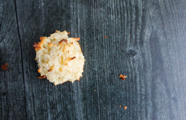 overhead view of a single coconut macaroon on a dark grey background