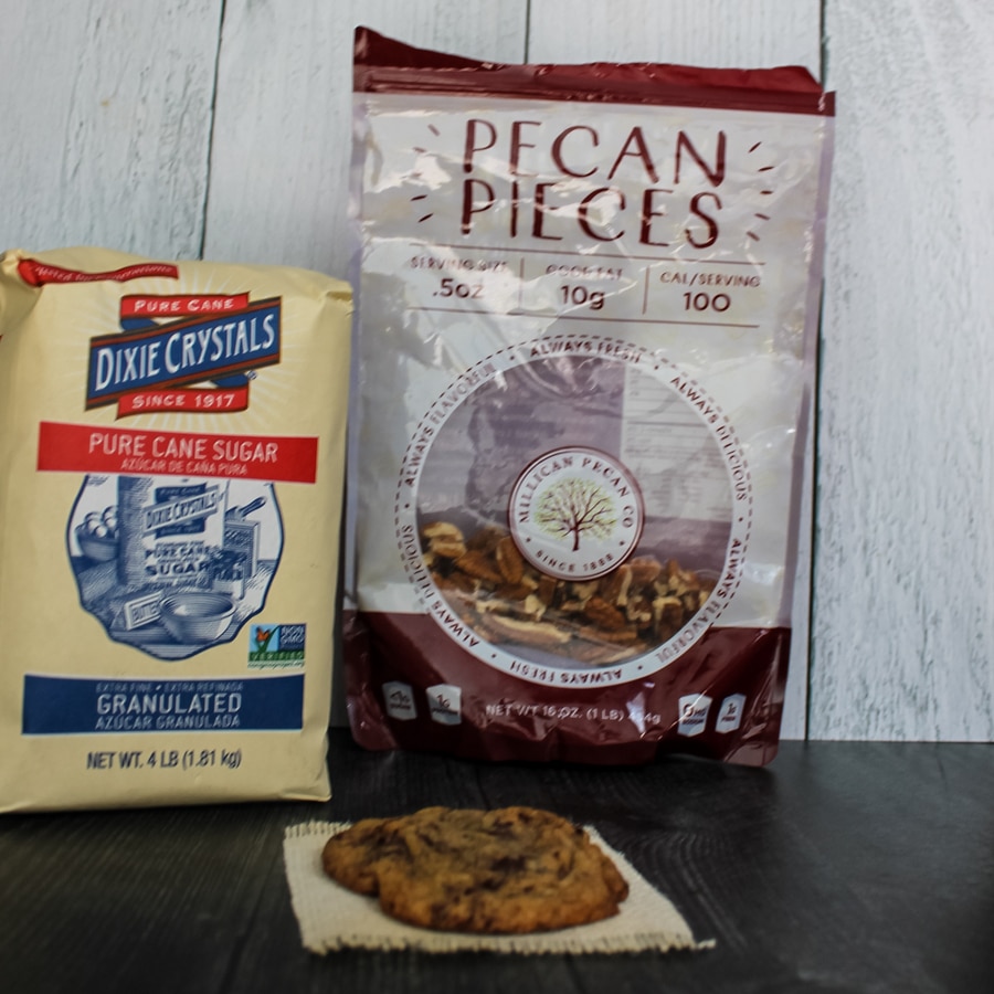 a Espresso Chocolate Chip Cookie with a bag of Dixie Crystals sugar and Millican Pecans